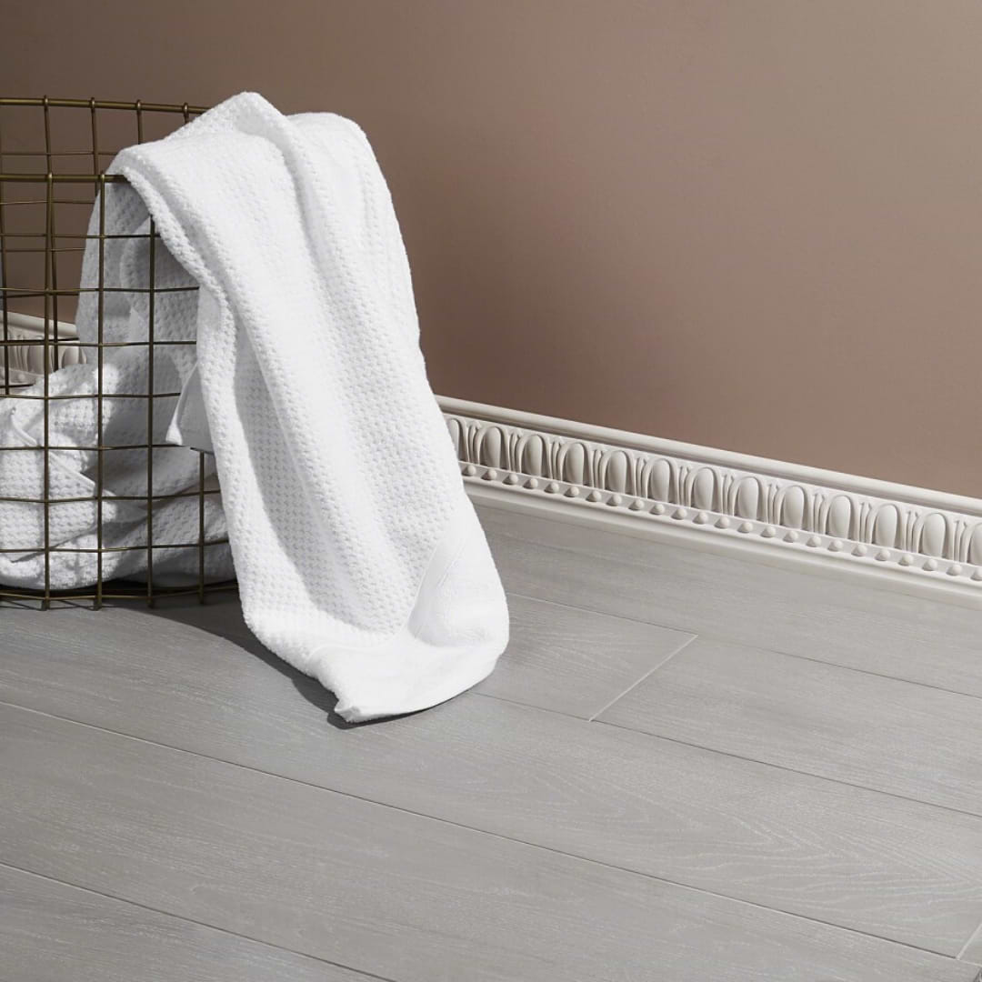 industry wood regent grigio 8x48 matte porcelain tile shown on floor with a towel basket 