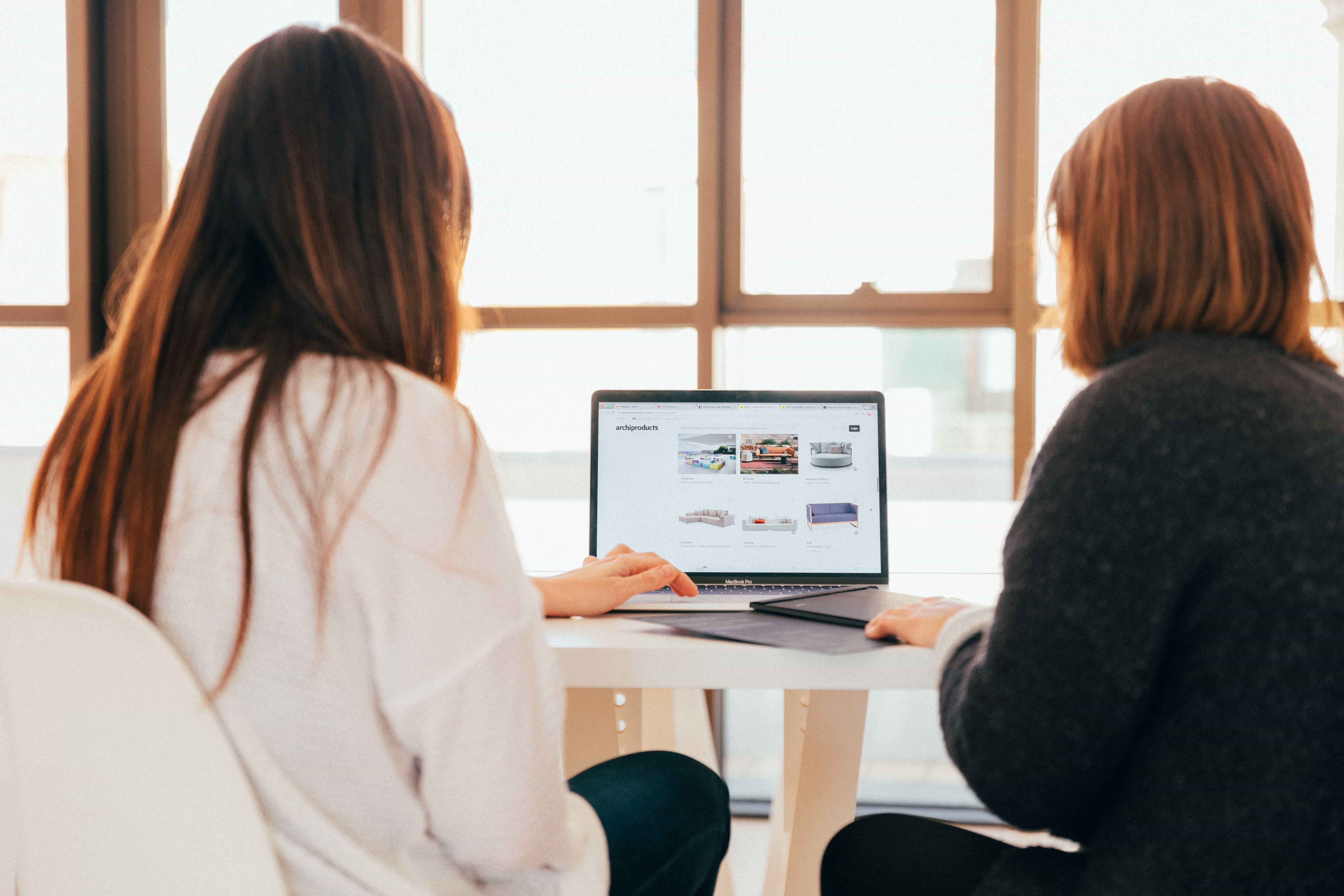 Two people sat looking at a laptop