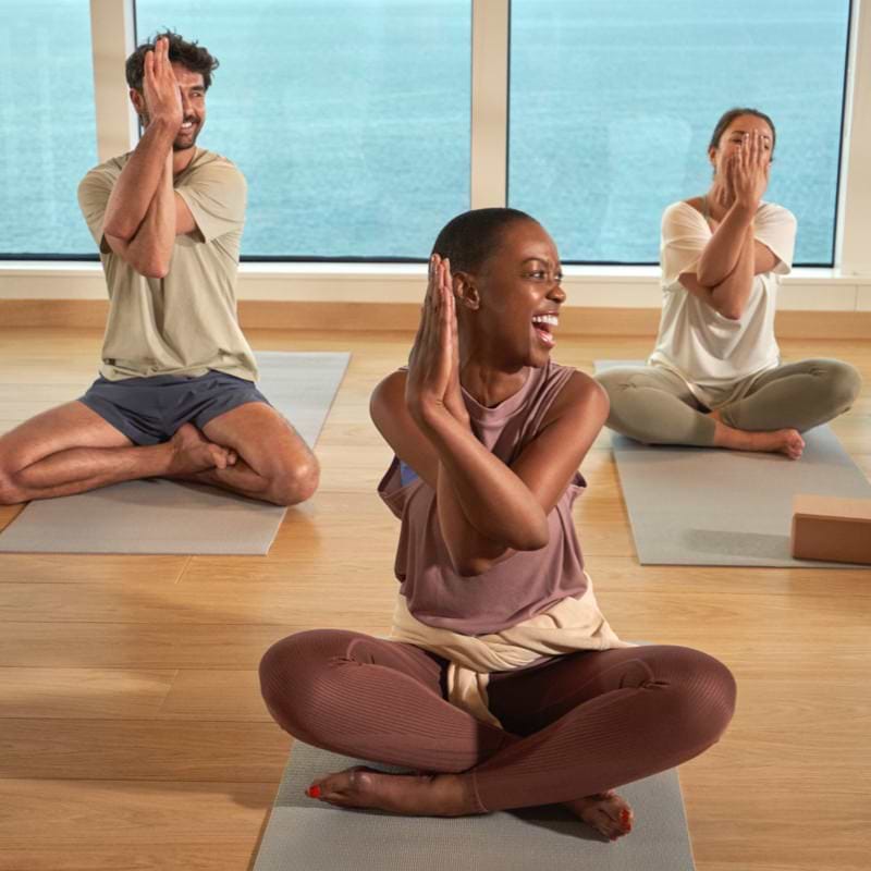 People sitting on mat during yoga session