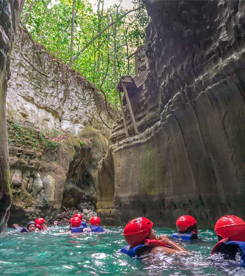 Portrait Carousel of people floating in river between two mountains