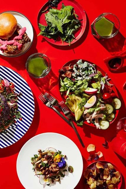 Burger plate and salad served at red table