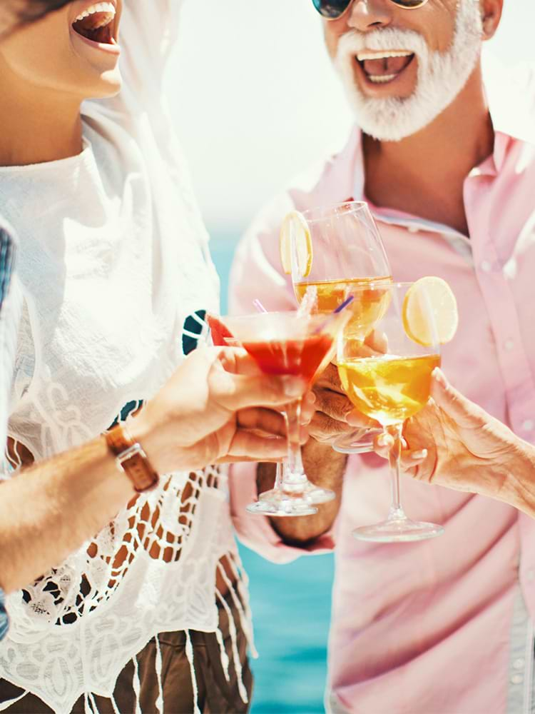 People smiling on cruise cheering with drinks