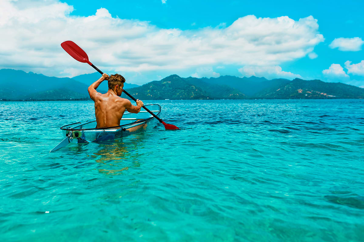 Kayaker rowing clear bottom kayak at Costa Maya waters