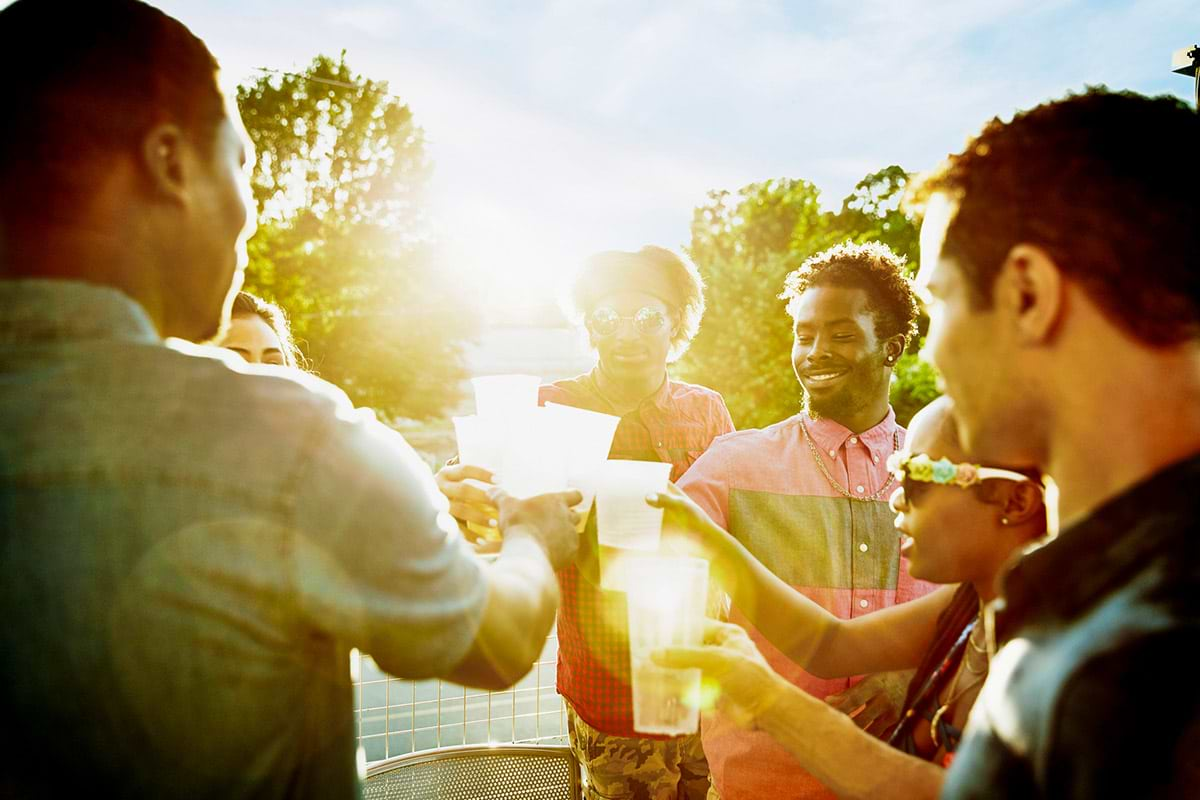 Group of people doing a cheers with beers in hand.