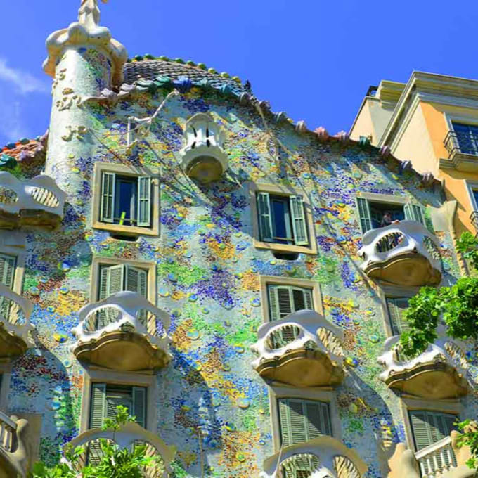 Casa Batlló, a historic building with blotches of color, unique balconies, and picturesque window shutters.